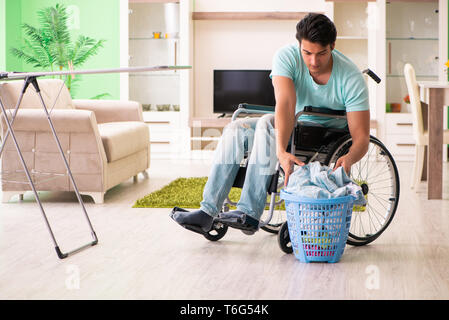 Disabled man on wheelchair doing laundry Stock Photo