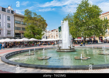 People around fountain on Stefan Stambolov square in center of Plovdiv city. Spring time. Stock Photo