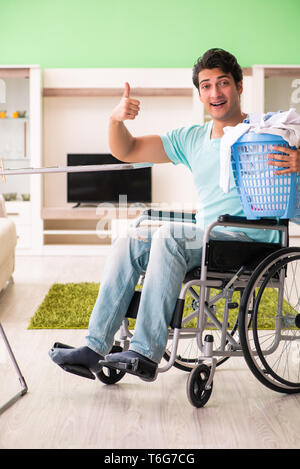 Disabled man on wheelchair doing laundry Stock Photo