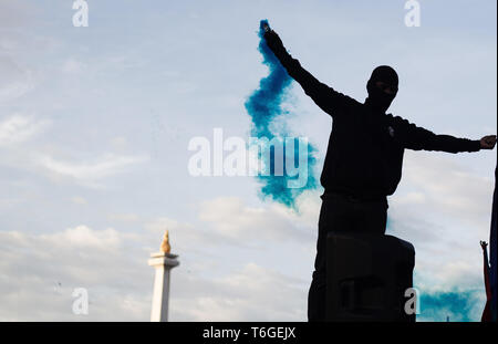 Jakarta, DKI Jakarta, Indonesia. 1st May, 2019. A demonstrator seen with a flare during the commemoration.Workers marched demonstrating while commemorating May Day 2019, they demand for the government to immediately revoke Government Regulation No. 78 of 2015 concerning Wages. Credit: Nick Hanoatubun/SOPA Images/ZUMA Wire/Alamy Live News Stock Photo