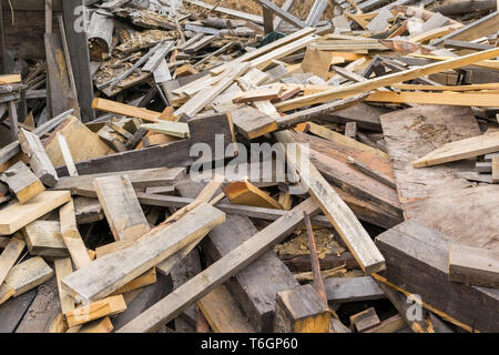 Piled in a pile of debris, pieces of boards, plywood and concrete blocks. Lumber, garbage, firewood Stock Photo