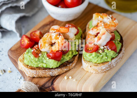 Avocado Shrimp Bruschetta With Cherry Tomatoes On Wooden Serving Board. Closeup View. Healthy Appetizer Or Snack Stock Photo