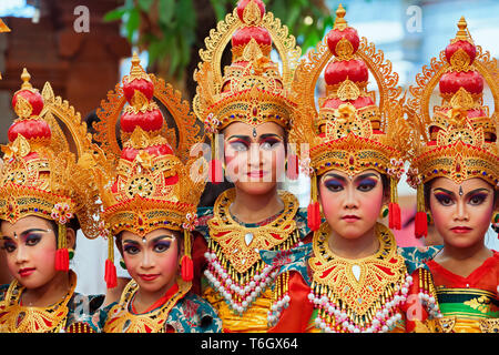 Denpasar, Bali island, Indonesia - July 11, 2015: Portrait of beautiful young Balinese women in ethnic dancer costume dancing traditional temple dance Stock Photo