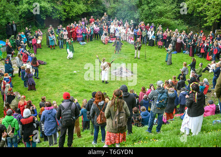 Crowds surround a fire during the Beltane celebrations at Glastonbury Chalice Well, where people gather to observe a modern interpretation of the ancient Celtic pagan fertility rite of Spring. Stock Photo