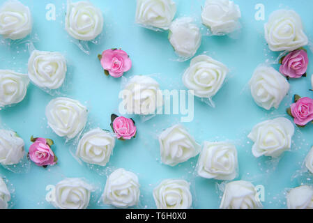 Artificial white and pink roses on blue background Stock Photo