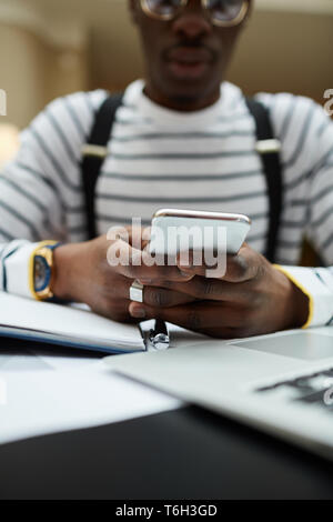 Close up  of contemporary African student using smartphone while studying in library, copy space Stock Photo