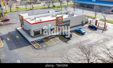 A drone / aerial view of a burger king restaurant with cars in the parking lot. Stock Photo