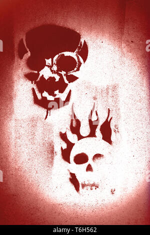 Two skulls in red spray painted on concrete Stock Photo