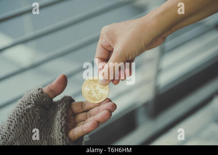 Homeless. Unhappy homeless man with black gloves is holding hand to get bit coins or help food donation from the people. Stock Photo