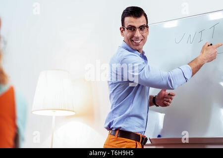 Joyful professional teacher smiling to his student Stock Photo