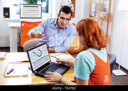 Nice pleasant woman looking at the laptop screen Stock Photo