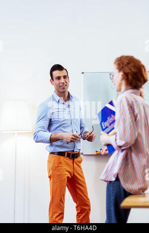 Joyful cheerful man standing in the classroom Stock Photo