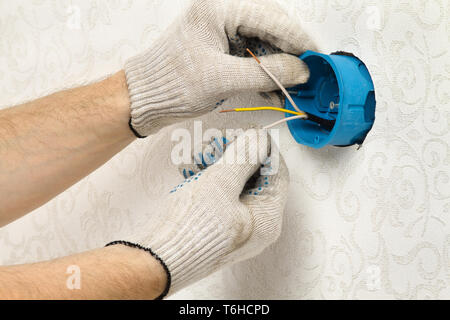 hands of an worker install the socket box on the wall Stock Photo
