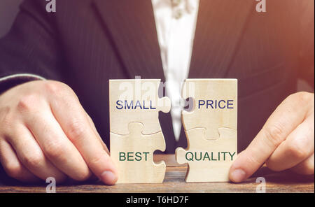 A businessman collects wooden puzzles with the words Small price - best quality. The concept of profitable deals for buyers. Low cost of goods. Qualit Stock Photo