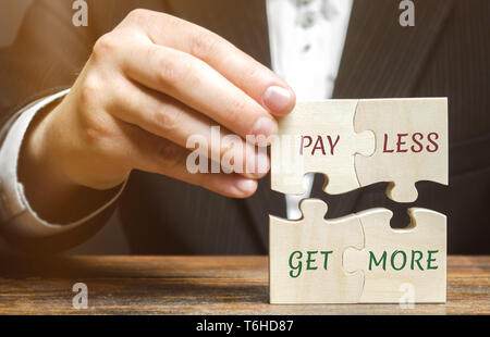 Businessman collects wooden puzzles with words Pay less get more. Offer discounts. Savings when buying. Big sale. The concept of business and finance. Stock Photo