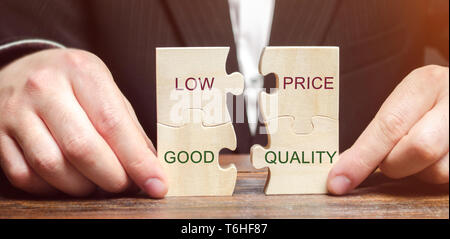A businessman collects wooden puzzles with the words Low price - good quality. The concept of profitable deals for buyers. Small cost of goods. Qualit Stock Photo
