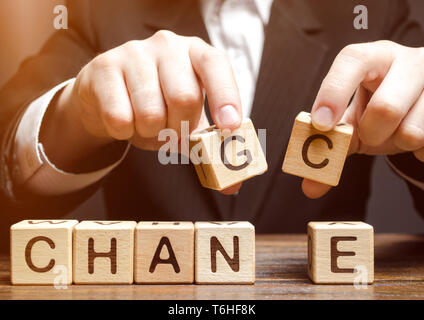 Businessman holding wooden blocks with the word Change to Chance. Personal development. Career growth or change yourself concept. Motivation, goal ach Stock Photo
