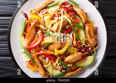 Delicious coleslaw salad with chicken, avocado and vegetables close-up on a plate on the table. horizontal top view from above Stock Photo