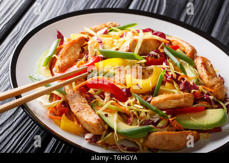 Dietary spicy Asian coleslaw salad with chicken, avocado and vegetables close-up on a plate on the table. horizontal Stock Photo