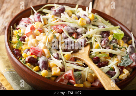 Vegetable coleslaw salad with beans, corn, pepper and herbs closeup in a plate on the table. horizontal Stock Photo
