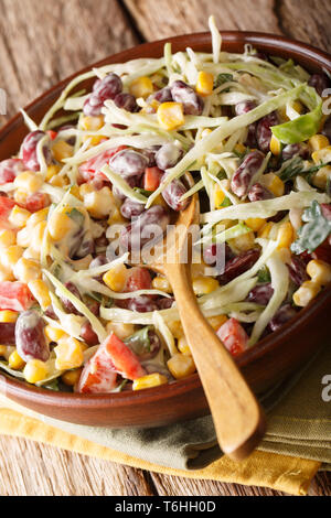 Mexican coleslaw salad with beans, corn, pepper and herbs closeup in a plate on the table. vertical Stock Photo