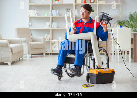 Disabled man repairing chair in workshop Stock Photo