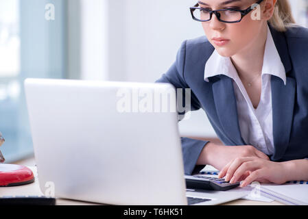 Female finance professional working on keyboard with reports Stock Photo