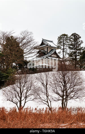 Kanazawa castle, Japan, wintertime, after snowfall. Hishi Yagura, turret, seen from the Shin-maru with Shissei-en garden in foreground. (Water garden) Stock Photo