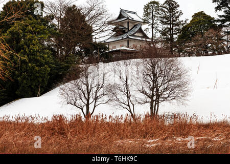 Kanazawa castle, Japan, wintertime, after snowfall. Hishi Yagura, turret, seen from the Shin-maru with Shissei-en garden in foreground. (Water garden) Stock Photo