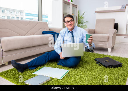 Businessman taking work home and working overtime Stock Photo