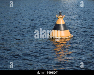 Yellow-black buoy in the water Stock Photo