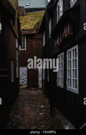 Small alley in the centre of Tórshavn (capital of Faroe Islands) with typical wooden houses with moss-covered roofs and dried fish (Faroe Islands) Stock Photo