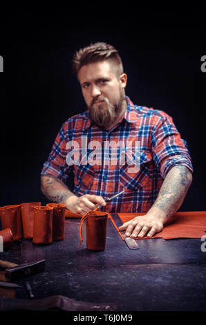 Craftsman creating a new leather product at his workshop Stock Photo