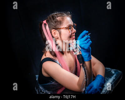 Tattoo artist poses in a tattoo studio Stock Photo