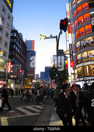People walk across the streets in the very busy Shinjuku district in Tokyo, Japan Stock Photo