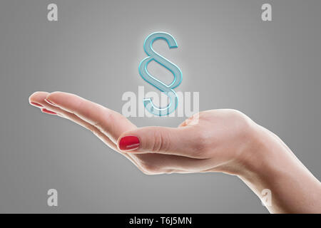 Female hand holding 3d paragraph symbol. Concept for justice. Stock Photo