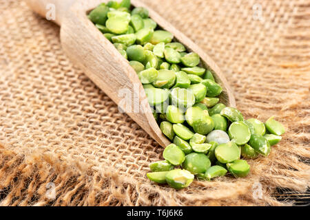 Dry green peas in a scoop on burlap close-up Stock Photo