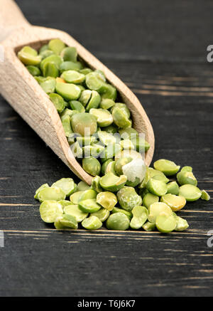 Dry green peas in scoop on wooden background closeup Stock Photo