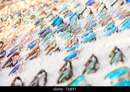 Colorful variety of cheap sunglasses displayed on market stall for sale Stock Photo