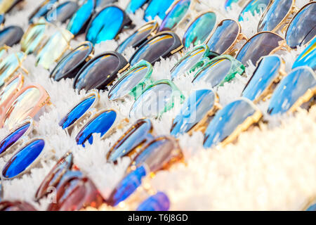 Colorful variety of cheap sunglasses displayed on market stall for sale Stock Photo