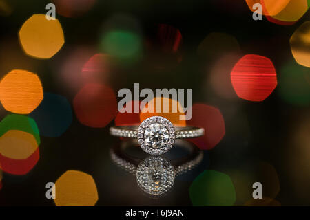 Engagement ring with a reflection of bokeh lights. Stock Photo