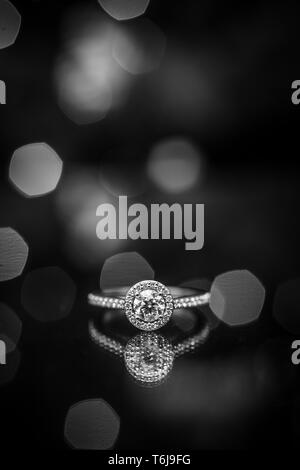 Engagement ring with lights in the background and a reflection below. Stock Photo