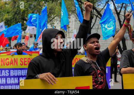 Workers are seen holding placards while shouting slogans during the rally. Thousands of workers are urging the government to raise minimum wages and to improve working conditions. Stock Photo