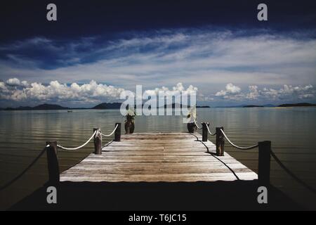 Wooden pier leading in the Andaman sea on tropical island Ko Lanta, Thailand Stock Photo