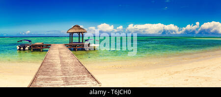 Sandy tropical beach. Jetty on the foreground. Panorama Stock Photo