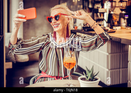 Cheerful short-haired senior lady posing with wide smile Stock Photo