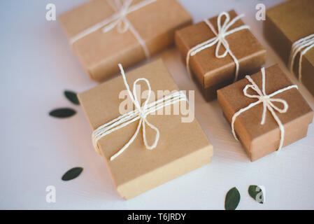 Craft gift boxes on white wooden background. Stock Photo
