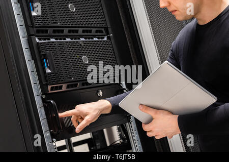 IT Support Holding Digital Tablet Examining and Perform Service on Servers Stock Photo
