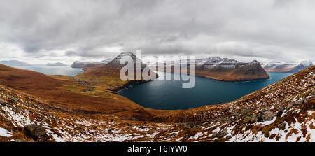 Panoramic view from Kap Enniberg to the small village Viðareiði, its fjords, Kunoy island and snow-covered mountains (Faroe Islands, Denmark, Europe) Stock Photo