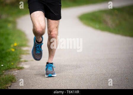 Senior man in 50s exercising and keeping fit by running in a park Stock Photo